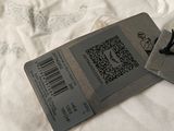two luggage tags on a bed with a white comforter