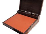 an open wooden box with an orange paper inside of it