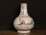 a vase with a bird on it sitting on a table