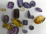 purple and yellow gems are arranged on a white surface