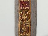 an old book sitting on top of a table next to a white wall