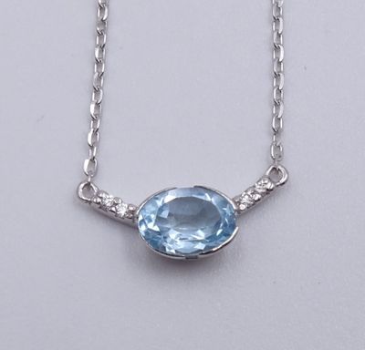 un gros plan d'un collier en topaze bleue sur fond blanc