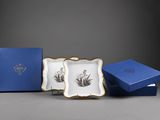 trois assiettes bleues et blanches et une boîte bleue posées sur une surface grise