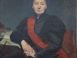 portrait of a woman in a red sash sitting at a desk