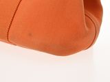 an image of a close up of an orange purse on a white surface