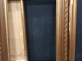 two gold picture frames sitting next to each other on a table
