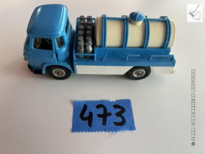un petit camion bleu avec une pancarte sur laquelle on peut lire « e fn »