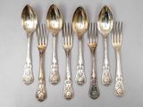 six cuillères en argent et une fourchette sont alignées sur une table
