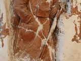 une statue représentant un homme tenant un bâton, accrochée à un mur