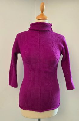 pull à col roulé violet sur un mannequin de vitrine