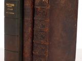 two old books sitting on top of each other on a table