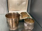 des tasses et des cuillères en argent posées sur une table en verre