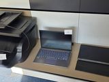 une imprimante et un ordinateur portable posés sur un bureau dans une pièce