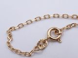 a close up of a gold chain bracelet on a white surface