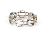 un gros plan sur un bracelet en argent et or rose orné de cercles