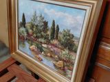 a picture of a painting hanging on a wall next to a wooden chair