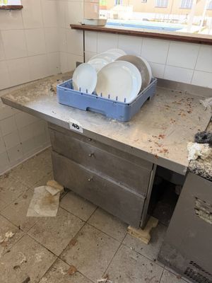 une cuisine sale équipée d'un évier et d'un lave-vaisselle
