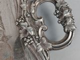 a silver plate with a handle and flowers on it