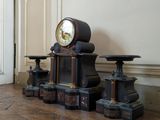 a clock that is sitting on the floor in front of a wall