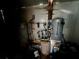 une photo d'une pièce où se trouvent un chauffe-eau et de nombreux outils