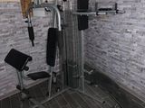 une photo d'une salle de sport à domicile équipée d'un banc et d'appareils de musculation