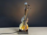 a lamp that is sitting on a table next to a guitar