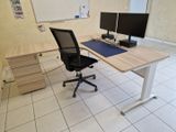 un bureau équipé de deux écrans et d'une chaise dans la pièce