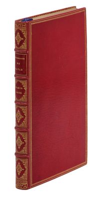 un vieux livre avec une couverture rouge et des bordures dorées sur fond blanc