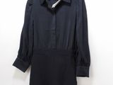 a black dress hanging on a hanger against a white wall