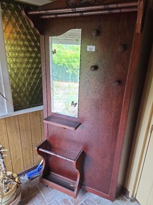 une porte en bois sur laquelle est accroché un miroir, dans un coin de la pièce