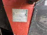 a close up of a red machine with a metal plate on it