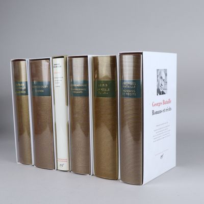 four books in a row on a white surface with a box