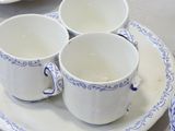 three cups and saucers on a plate on a table