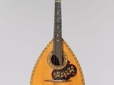 a guitar hanging from a string on a wall