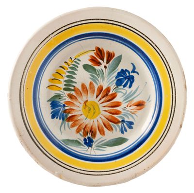 a plate with a flower design on it on a white background