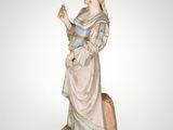 an antique figurine of a woman holding a basket