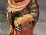 wooden statue of a man holding a dog on a gray background