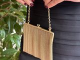 the woman is wearing a black dress and holding a gold purse