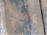 a close up of a bed with a blue and white floral pattern