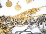 a lot of gold and silver chains on a white surface