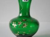 un vase en verre vert orné de fleurs dorées