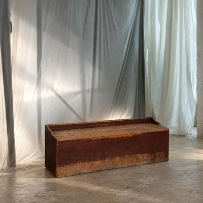 un banc en bois devant un rideau, dans une pièce