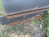 a black grill sitting in the grass on the side of the road