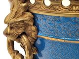 a blue and gold vase with a lion head on it