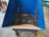 a blue wheelbarrow in the middle of a room