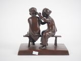 statue of a man and woman sitting on a bench with a white background