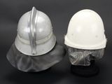 two white helmets sitting on top of each other on a black surface