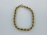 un bracelet en corde dorée sur fond blanc