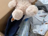 a teddy bear that is sitting in a cardboard box