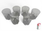 six glasses are lined up in a row on a white surface
